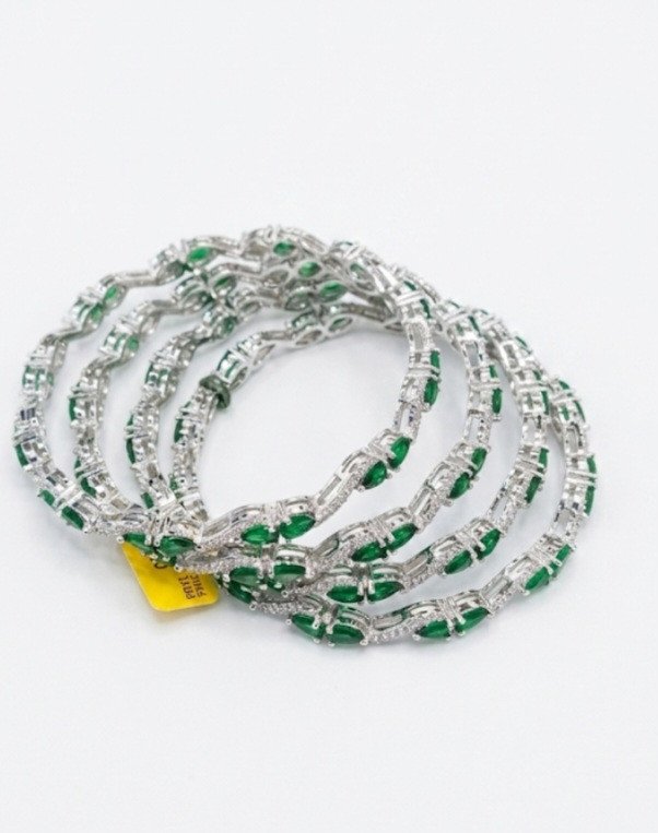 silver-tone bangles featuring green stones